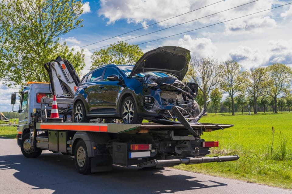 Tow truck carrying a damaged vehicle